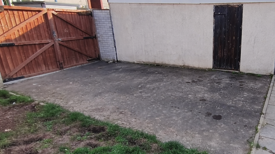 Before driveway cleaning: surface with dark staining and moss buildup