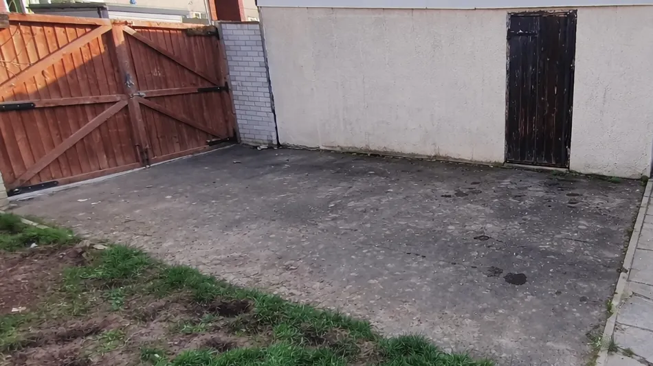 Before driveway cleaning: surface with dark staining and moss buildup